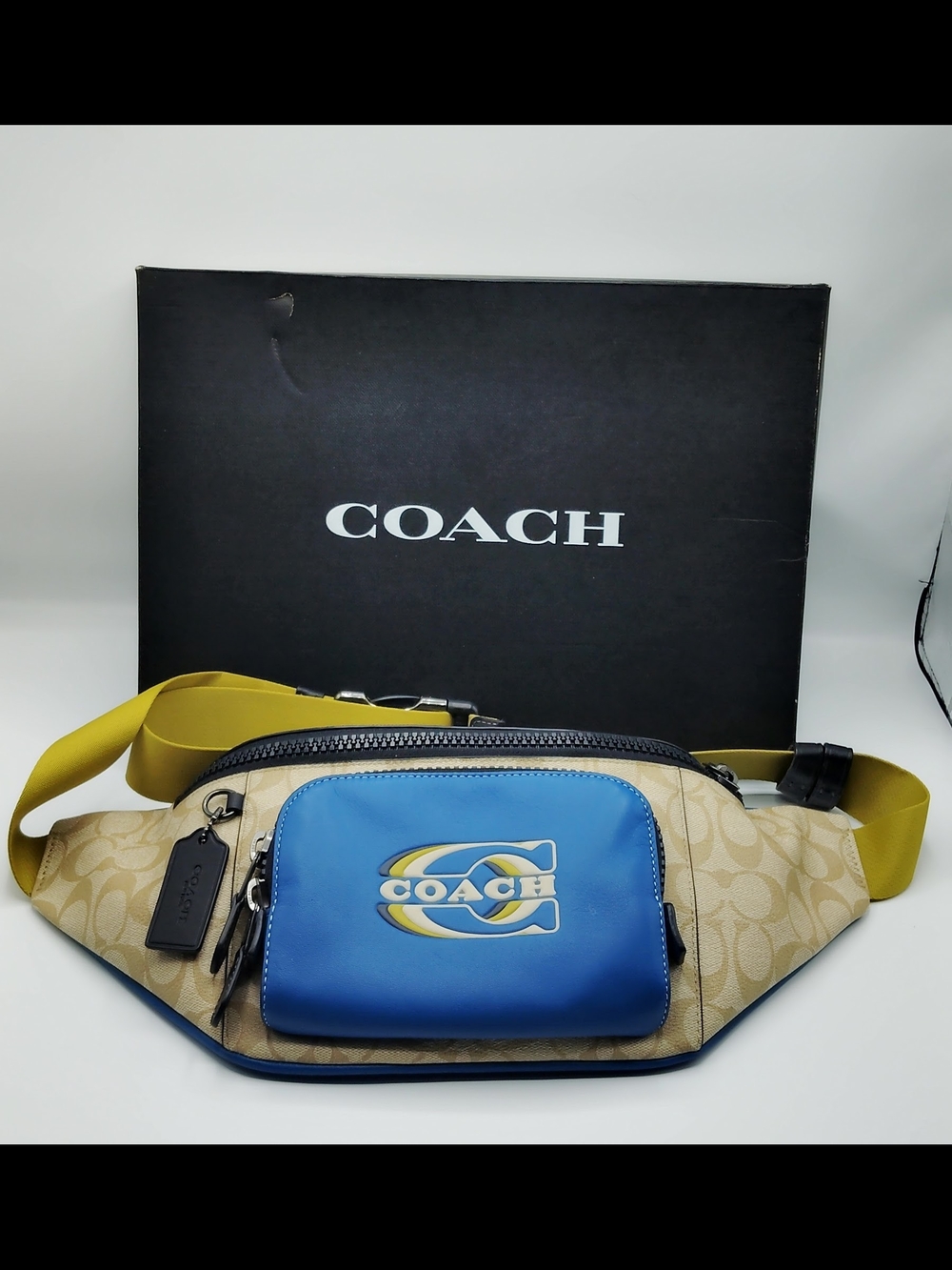 Coach Beige Signature Canvas Belt Bag with Blue Logo Pocket and Yellow Strap.